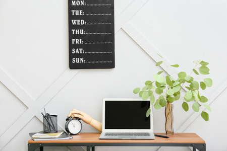 Interior of modern workplace with wooden hand and laptopの写真素材