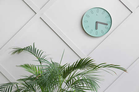 Stylish clock hanging on light wallの写真素材