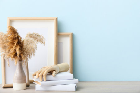 Wooden hand with books and decor on table