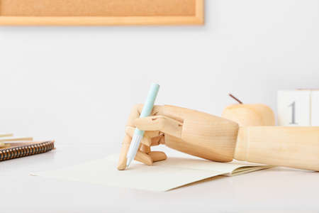 Wooden hand with pen and notebook on table, closeupの写真素材