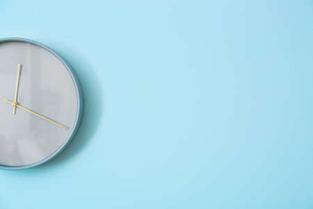 Stylish clock hanging on color wallの写真素材