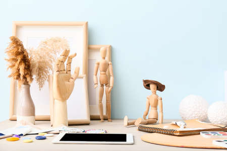 Creative composition with wooden mannequins and artist supplies on tableの写真素材