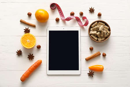 Healthy products, measuring tape and tablet computer on light wooden backgroundの写真素材