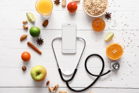 Healthy products, mobile phone and stethoscope on light backgroundの写真素材