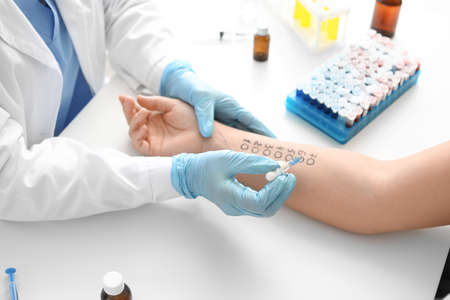 Young woman undergoing procedure of allergen skin tests in clinic