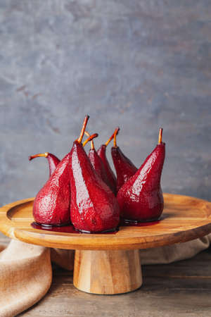 Dessert stand with sweet poached pears in red wine on dark backgroundの写真素材