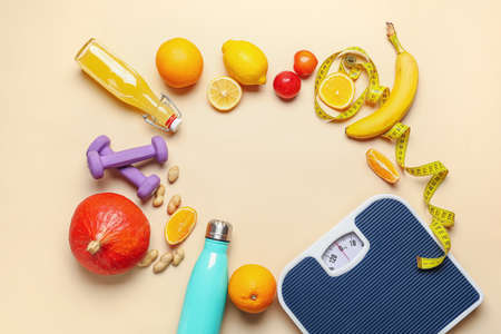 Frame made of fresh products, scales, dumbbells and measuring tape on color background. Diet conceptの写真素材