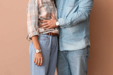 Happy young couple on color backgroundの写真素材