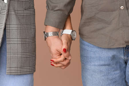 Young couple holding hands on color backgroundの写真素材
