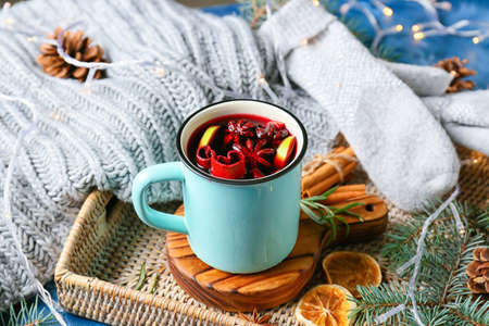 Cup of tasty mulled wine on wicker trayの写真素材