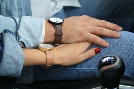 Young couple holding hands in carの写真素材