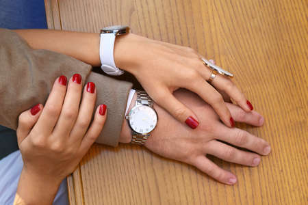 Young couple holding hands on wooden tableの写真素材