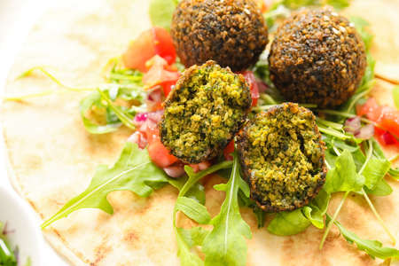 Tasty falafel balls, pita and vegetables, closeup