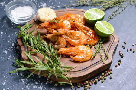 Board with tasty shrimps on dark backgroundの写真素材