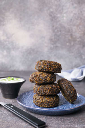 Plate with tasty falafel balls and sauce on dark backgroundの写真素材