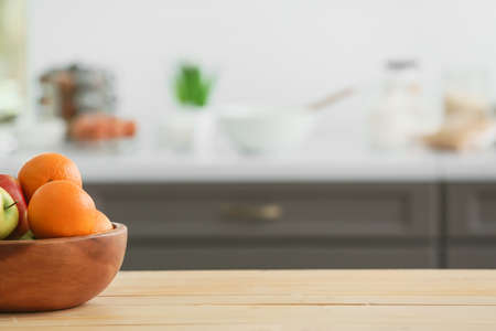 Bowl with fruits on table in modern kitchenの写真素材