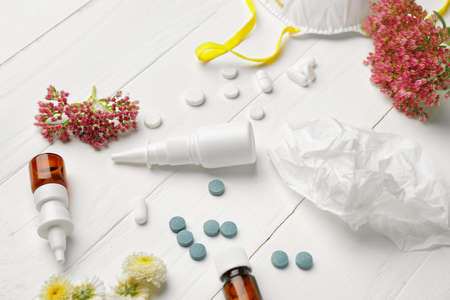 Composition with bottles of drops, flowers and respirator on light wooden backgroundの写真素材