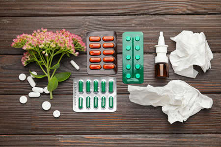 Composition with bottle of drops, flower and used tissues on wooden backgroundの写真素材