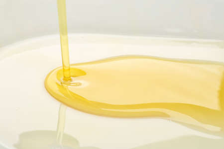 Pouring of olive oil, closeup view