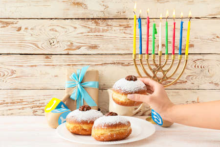 Woman eating tasty donut for Hanukkah