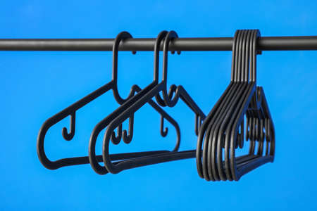 Rack with clothes hangers on color backgroundの写真素材