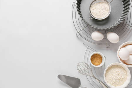 Set of kitchen utensils and ingredients for preparing bakery on light backgroundの写真素材