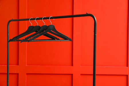 Rack with clothes hangers on color backgroundの写真素材