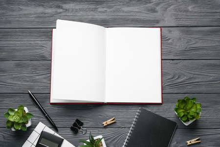 Blank open book and stationery on wooden backgroundの写真素材
