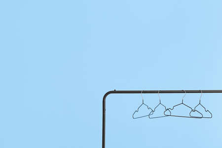 Rack with clothes hangers on color backgroundの写真素材