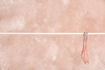 Rack with clothes hangers on color background