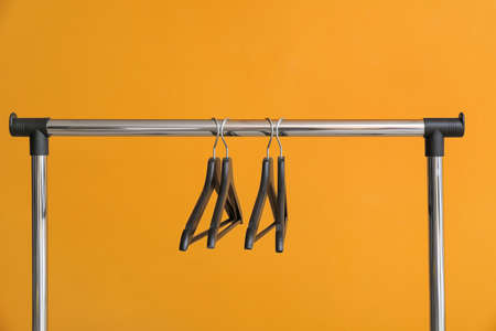 Rack with clothes hangers on color backgroundの写真素材