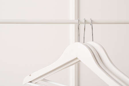 Rack with clothes hangers on white background