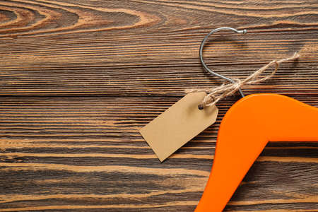 Clothes hanger with tag on wooden backgroundの写真素材