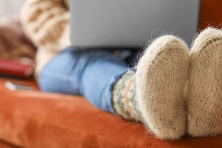 Legs of young woman in warm socks at homeの写真素材