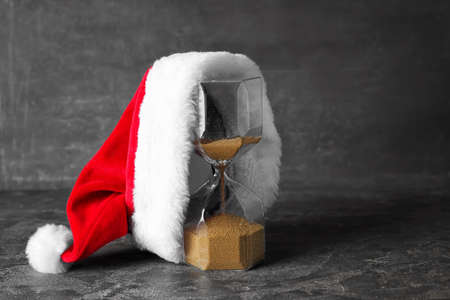 Santa hat with hourglass on dark backgroundの写真素材