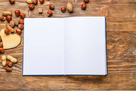Blank book with nuts on wooden backgroundの写真素材