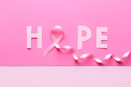 Pink ribbon and word HOPE on color background. Breast cancer awareness conceptの写真素材