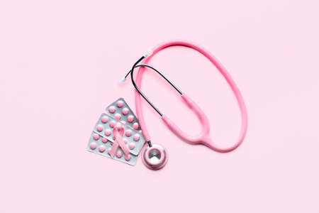 Pink ribbon, remedy and stethoscope on color background. Breast cancer awareness conceptの写真素材