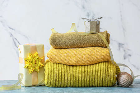 Stylish Christmas clothes with gift on table