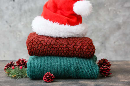 Stylish Christmas clothes with Santa Claus hat on grunge backgroundの写真素材