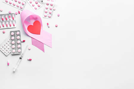 Pink ribbon, remedy and heart on light background. Breast cancer awareness concept