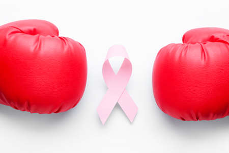 Pink ribbon and boxing gloves on light background. Breast cancer awareness conceptの写真素材