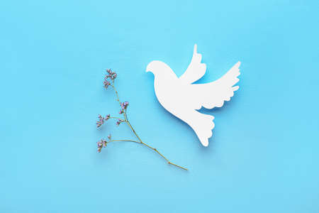 Paper dove on color background. International Day of Peaceの写真素材