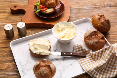 Bun with tasty cream cheese on wooden backgroundの写真素材