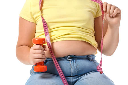 Overweight girl with dumbbell and measuring tape on white backgroundの写真素材