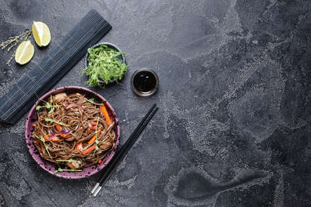 Plate with tasty soba noodles and meat on dark backgroundの写真素材