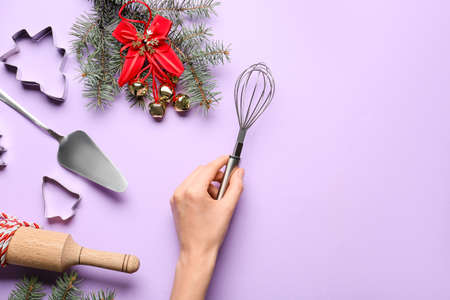 Female hand with whisk on color backgroundの写真素材