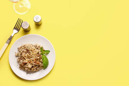Plate with tasty risotto on color background