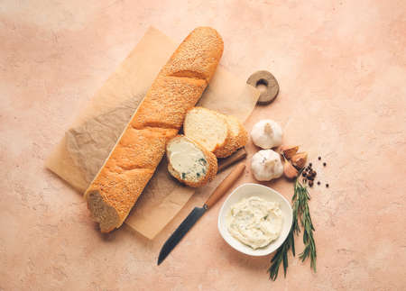 Fresh bread, garlic butter and ingredients on color backgroundの写真素材