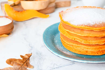 Tasty pumpkin pancakes on table